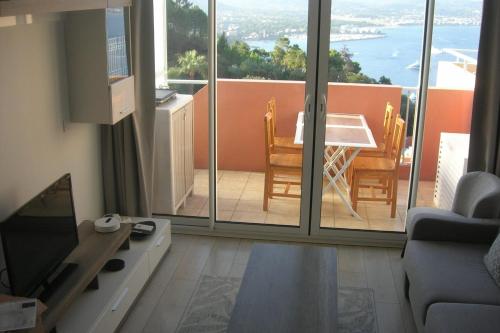 - un salon avec un balcon doté d'une table et de chaises dans l'établissement Renovated apartment in quiet residence, à Théoule-sur-Mer