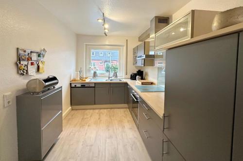 une cuisine avec des placards gris et un comptoir dans l'établissement Ferienhaus Stettiner Str 4b, à Westerland