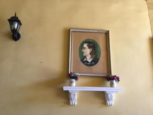 a painting of a woman on a wall with a shelf at Apartman Brankova kuća in Sremski Karlovci