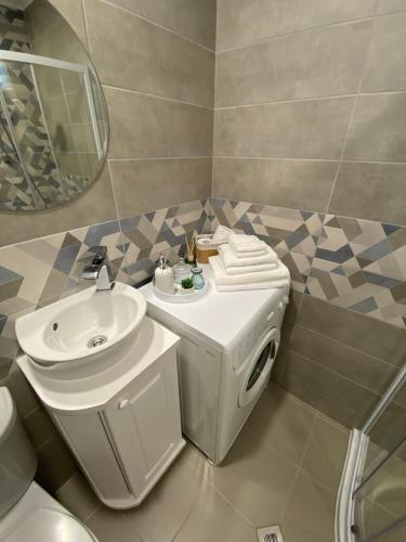 a bathroom with a sink and a toilet and a mirror at Апартамент "Smiley Place" in Vratsa