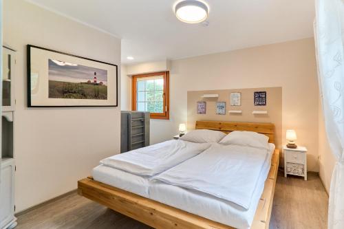 a bedroom with a large bed with white sheets at Liten Lycka in Simonsberg