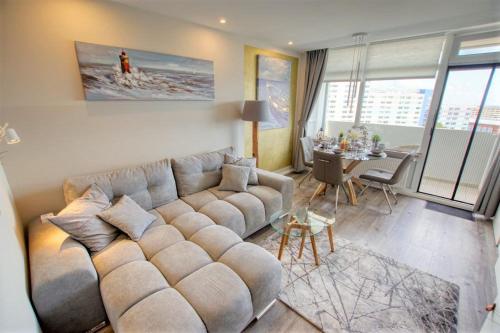 a living room with a large couch and a table at Ferienpark - Haus K, App 0K0801 in Heiligenhafen