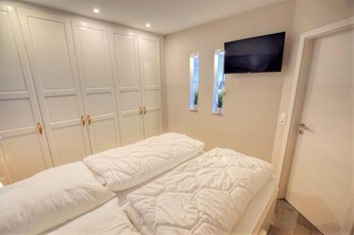 two beds in a room with white cabinets at Ferienpark - Haus K, App 0K0801 in Heiligenhafen