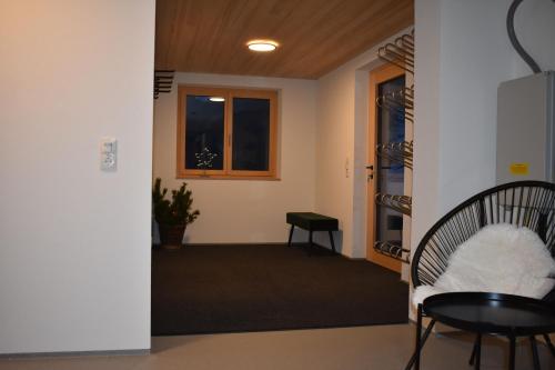 a hallway with a chair and a table and a window at Ferienwohnung BergTraum in Schoppernau