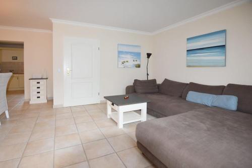 ein Wohnzimmer mit Sofa und Tisch in der Unterkunft Ferienhaus Silwai 20b in Tinnum