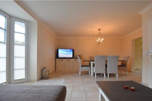 ein Wohnzimmer mit einem Esstisch und einem TV in der Unterkunft Ferienhaus Silwai 20b in Tinnum