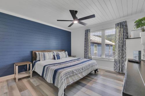 a blue bedroom with a bed and a ceiling fan at FLAT Lakefront Home w/ Dock-Kayaks-Paddle Board in Sandlick