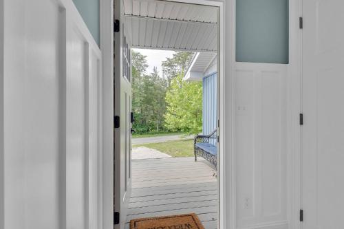 an open door to a porch with a bench at FLAT Lakefront Home w/ Dock-Kayaks-Paddle Board in Sandlick