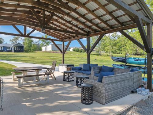 a pavilion with couches and tables and a picnic table at FLAT Lakefront Home w/ Dock-Kayaks-Paddle Board in Sandlick