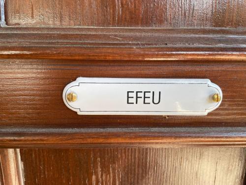a sign on a wooden door with the word epeu on it at Efeu Altstadtflair in Lübbenau