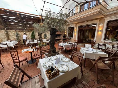 a restaurant with white tables and chairs and a glass ceiling at Gjuhadoli Hotel 2 in Shkodër