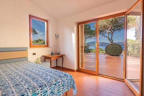 Casa MorconeにあるVilla Golfo Stellaのベッドとガラスの引き戸のある寝室