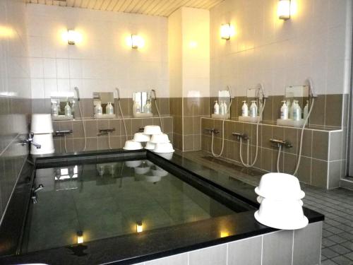 ein Badezimmer mit einem Pool, Waschbecken und Spiegeln in der Unterkunft Okadaya Bayside in Toyohashi