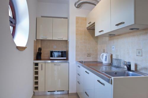 a kitchen with white cabinets and a microwave at ABA Apartamenty - Apartament Klasyczny centrum in Krynica Zdrój