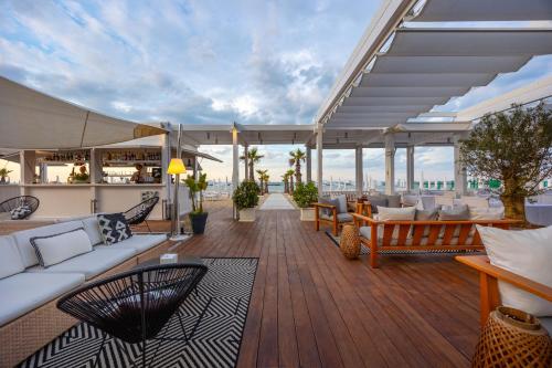 a living room with couches and chairs on a deck at Excelsior Hotel, SPA & Lido - Preferred Hotels & Resorts in Pesaro