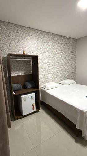 a bedroom with a bed and a wall with at AMPARO HOTEL in Ribas do Rio Pardo