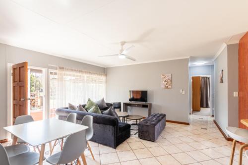 a living room with a couch and a table at Forest View Cottage in Muldersdrift