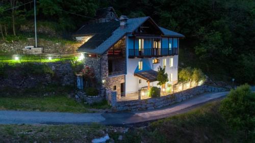 a small house with a balcony on a hill at night at Country House La Villa in Villadossola