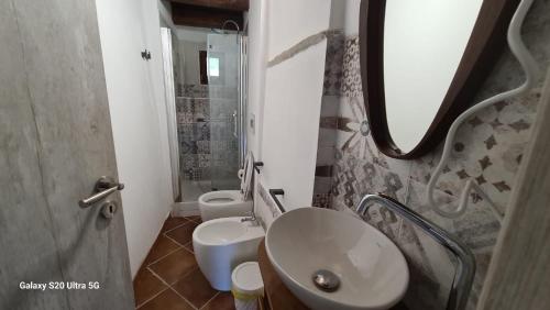 a bathroom with a sink and a toilet and a mirror at Country House La Villa in Villadossola