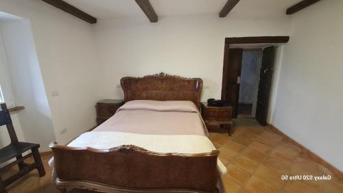 a bedroom with a wooden bed in a room at Country House La Villa in Villadossola