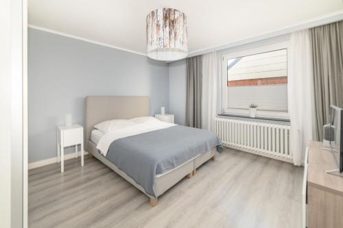 Un dormitorio blanco con una cama y una ventana. en Haus Monika, en Helgoland