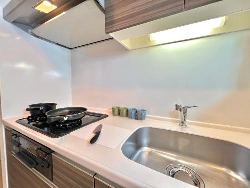 a kitchen with a sink and a stove at Shinjuku City Apt, 2DB , Free WiFi in Tokyo