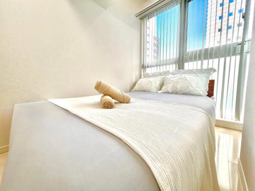 a bed with a teddy bear sitting on it in a window at Shinjuku City Apt, 2DB , Free WiFi in Tokyo