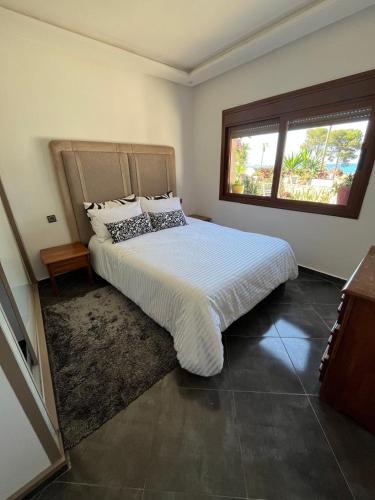 a bedroom with a large bed and a window at House near beach in M'diq