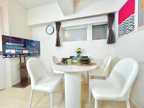 a white dining room with a white table and chairs at Shinjuku City Apt, 2DB , Free WiFi in Tokyo