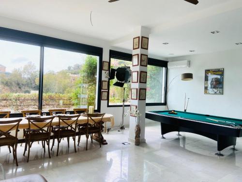 ein Esszimmer mit einem Billardtisch und Stühlen in der Unterkunft Villa con piscina by MO in Málaga
