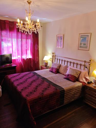a bedroom with a large bed and a chandelier at Casa do Lucio in Rianjo