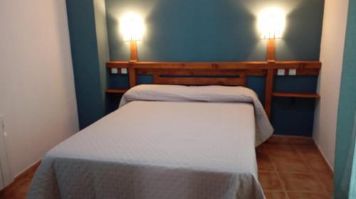 a small bedroom with two beds and two lights at Casa MªÁngeles in Puebla de Arenoso