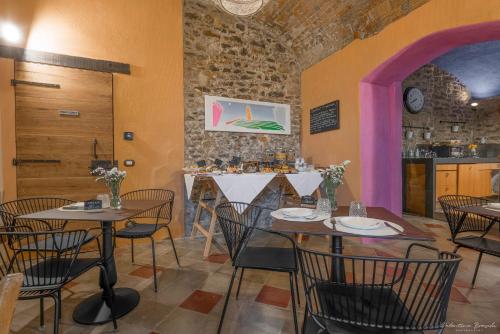 a restaurant with tables and chairs in a room at Palazzo d'Assi - Guest house in Monforte dʼAlba
