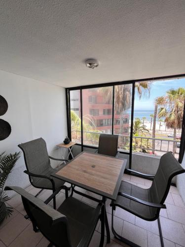 una sala da pranzo con tavolo e sedie e l'oceano di Departamento antiguo frente al mar a Iquique