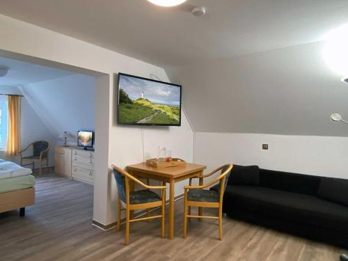 a living room with a couch and a table at Süderhaus Hiddensee App 12 in Neuendorf