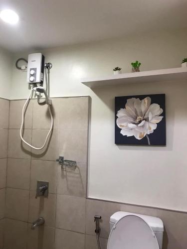 a bathroom with a shower with a flower on the wall at Persimmons Mabolo, Cebu City in Cebu City