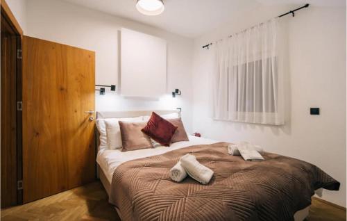 a bedroom with a large bed with two pillows on it at Stunning Home In Aljmas With Wifi in Aljmaš