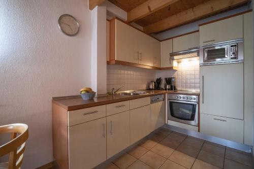 a kitchen with white cabinets and a sink and a stove at Ferienhäuser Greetsiel - Urlaub mit Haustier in Ostfriesland in Greetsiel