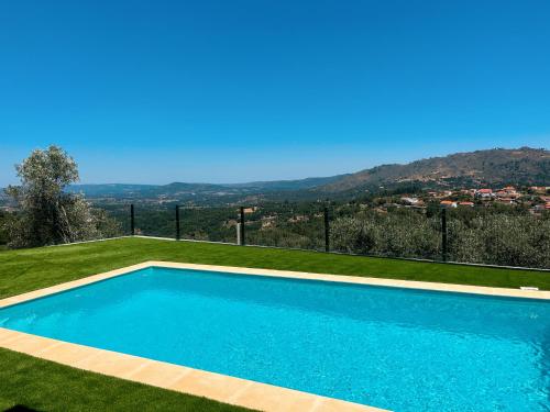 a swimming pool with a hill in the background at Casas Chão da Roseira in Celorico da Beira