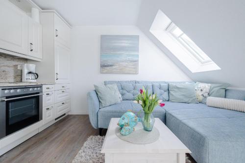 a living room with a blue couch and a table at Lister Wind in List