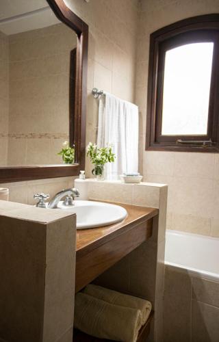 a bathroom with a sink and a tub and a mirror at LA AGUADA - Villa de Mar in Villa Gesell