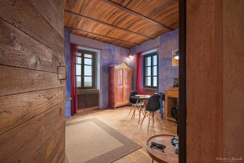 a room with blue walls and a table and chairs at Palazzo d'Assi - Guest house in Monforte dʼAlba