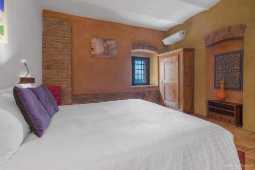 a bedroom with a large white bed in a room at Palazzo d'Assi - Guest house in Monforte dʼAlba