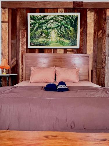a bedroom with a bed with two hats on it at Paddy View Hostel in Banyuwangi