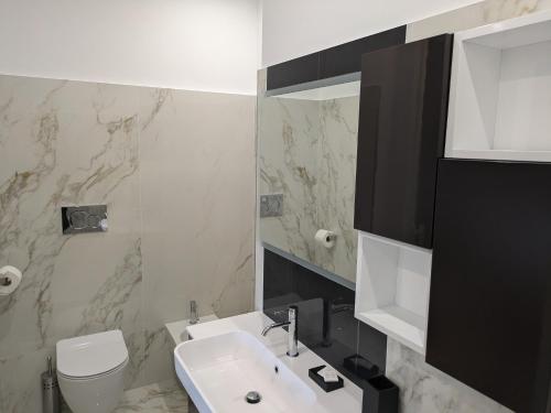 a bathroom with a sink and a toilet and a mirror at La casa di nonna in Montesano sulla Marcellana