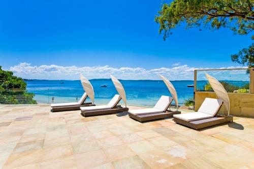 a group of chairs on a patio overlooking the ocean at Amarna Luxury Beach Resort in Nelson Bay