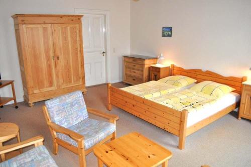 a bedroom with two beds and a chair and a table at Hof Kröger Ferienwohnung Nr 03 in Travemünde
