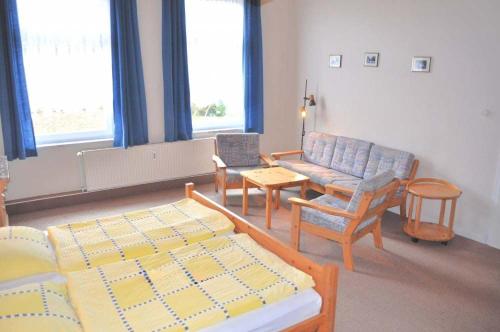 a room with two beds and a couch and a chair at Hof Kröger Ferienwohnung Nr 03 in Travemünde