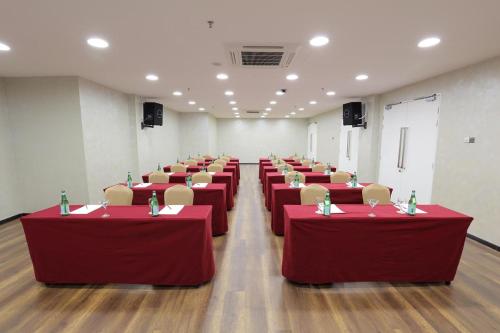 a conference room with red tables and chairs in it at Amerin Hotel Johor Bahru in Johor Bahru