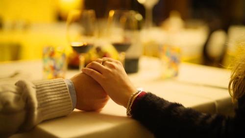 a woman sitting at a table with her hand on a counter at T'AMI Hotel Resort Spa in Selvino